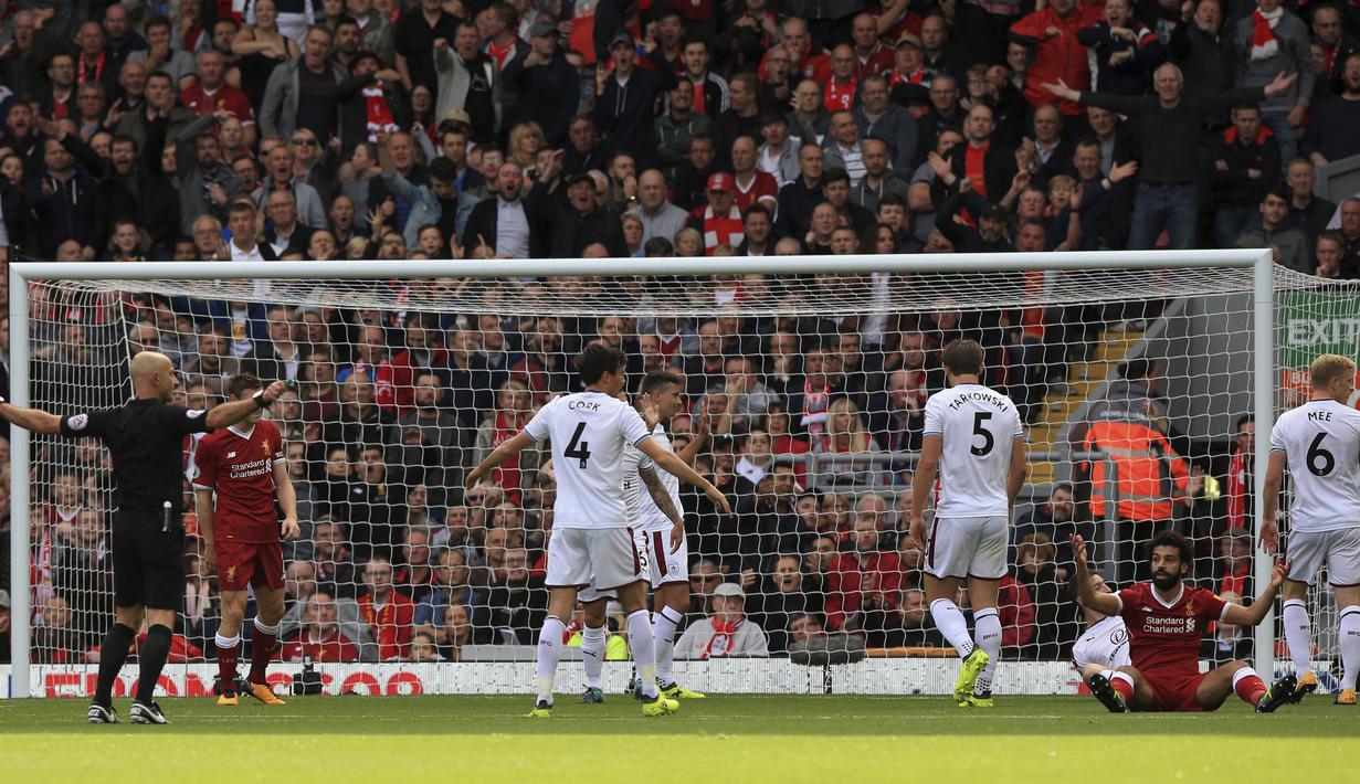 Mohamed Salah (2kanan) melakukan protes kepada wasit, Roger East (kiri) saat laga Liverpool melawan Burnley pada lanjutan Premier League pekan kelima di Anfield Stadium, Liverpool (16/9/2017). Liverpool bermain imbang 1-1. (Peter Byrne/PA via AP)
