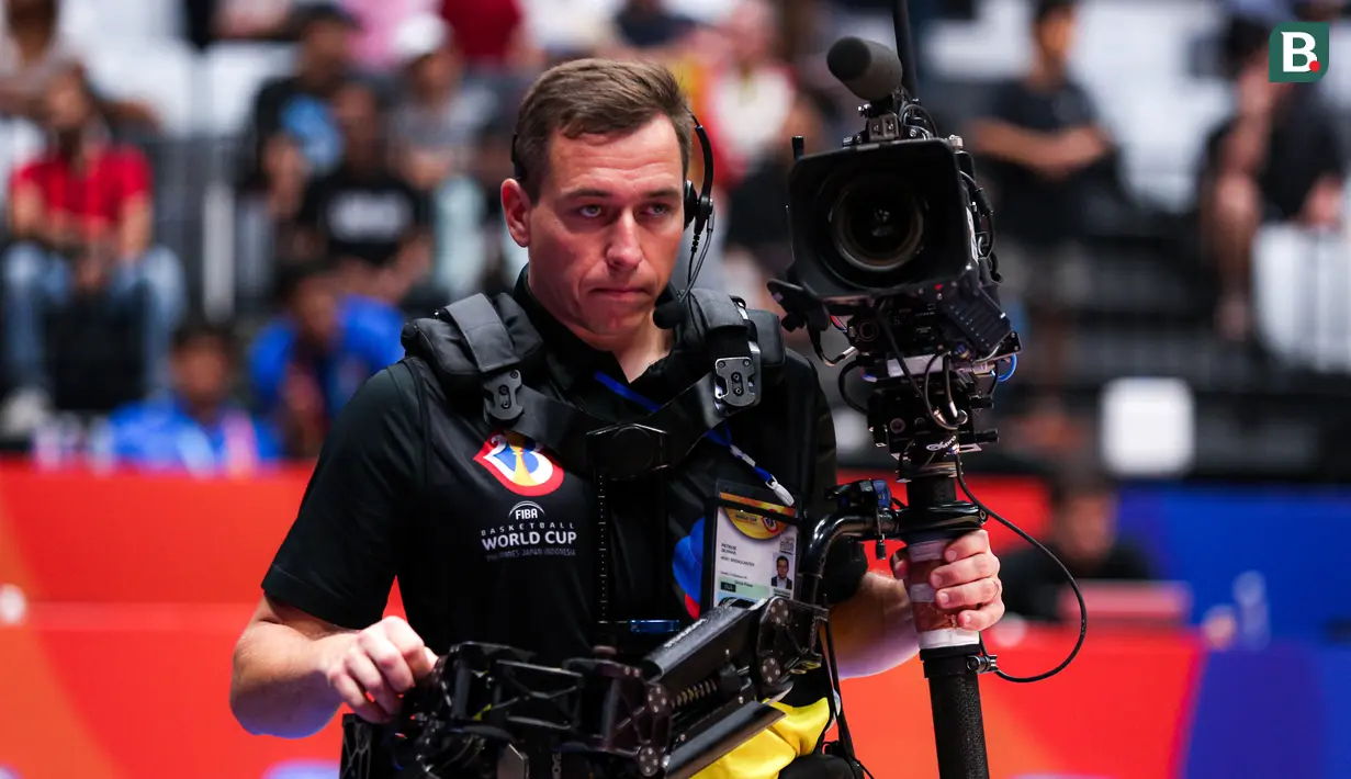Seorang kameraman dilengkapi dengan Camera Stabilizer Arm Vest saat melakukan tugasnya di Piala Dunia FIBA 2023 di Indonesia Arena, Senayan, Jakarta, Minggu (27/08/2023). Teknologi ini digunakan untuk mengambil gambar dari dekat. Penonton akan disajikan dengan momen yang lebih dekat. (Bola.com/Bagaskara Lazuardi)