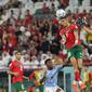 Bek dan kiper Maroko, Jawad El Yamiq dan Yassine Bounou meraih bola pada babak 16 besar Piala Dunia 2022 di Education City Stadium, Al Rayyan, Rabu (6/12/2022) dini hari WIB. Maroko melewati duel alot 120 menit untuk mengalahkan Spanyol di babak adu penalti dengan skor telak 3-0. (AP Photo/Julio Cortez)