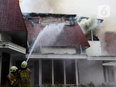 Petugas Pemadam Kebakaran dan Penyelamatan melakukan pemadaman api di salah satu rumah kawasan Menteng, Jakarta, Selasa (9/7/2024). (Liputan6.com/Herman Zakharia)