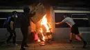 Sejumlah pelajar membakar kereta yang terparkir di Stasiun MTR Chinese University, Hong Kong, Rabu (13/11/2019). Gerakan antipemerintah Hong Kong yang telah berlangsung selama lima bulan bertindak semakin keras. (AP Photo/Kin Cheung)