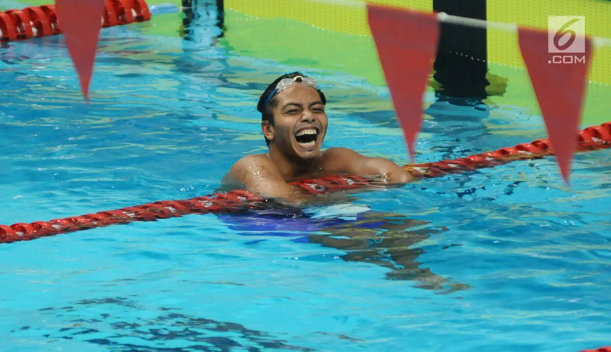 Perenang klub MNA, I Gede Siman Sudartawa tertawa usai menang di final gaya punggung 100 m putra Kejuaraan Akuatik Indonesia Open 2017 di Stadion Aquatik GBK, Jakarta, Minggu (10/12). Siman menorehkan waktu 56,19 detik. (Liputan6.com/Helmi Fithriansyah)