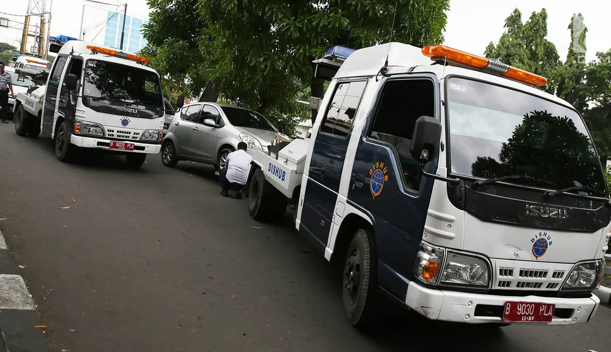 Sejumlah mobil derek petugas Dinas Perhubungan bersiap menderek kendaraan yang terjaring parkir liar di kawasan Pasar Baru, Jakarta, Kamis (14/12). (Liputan6.com/Immanuel Antonius)