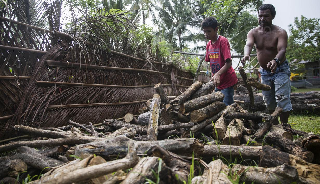 Pesepak bola SSB Tulehu Putra, Rizki Lestaluhu, saat berada di rumahnya di Tulehu, Maluku, Selasa (15/11/2017). Tiap hari Rizki membantu ayahnya bekerja memilihkan kayu bakar yang akan digunakan untuk memasak. (Bola.com/Vitalis Yogi Trisna)