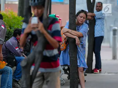 Sejumlah massa dari Koalisi Pejalan Kaki, KPBB, dan Thamrin School of Climate Change and Sustainability menggelar aksi #ayopelukpohonini di Jalan Sudirman, Jakarta, Jumat (22/9). (Liputan6.com/Faizal Fanani)