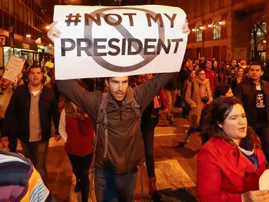 Pengunjuk rasa membawa poster bertuliskan "#Not My President" saat memprotes kemenangan Trump dalam pemilihan Presiden AS, di Chicago, Rabu (9/11). Mereka meneriakkan yel-yel bahwa Donald Trump "bukan presiden kami." (REUTERS/Kamil Krzacznski)