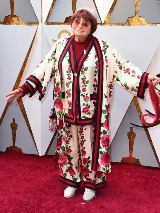 Agnes Varda (89) berpose di karpet merah Piala Oscar 2018, Los Angeles, Minggu (4/3). Sutradara Prancis yang filmnya Faces Places dinominasikan untuk Film Dokumenter Terbaik Oscar membuat linimasa Twitter heboh berkat gayanya. (Jordan Strauss/Invision/AP)