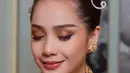 Wajah Nagita tampak dipulas dengan makeup flawless. Eyeshadow matte coklat dan shimmer bronze tampak diaplikasikan di kelopak matanya. Ditambah dengan bulu mata palsu natural yang membuat mata Nagita terlihat lebih tajam. [@raffinagita1717/@erniaredberry]