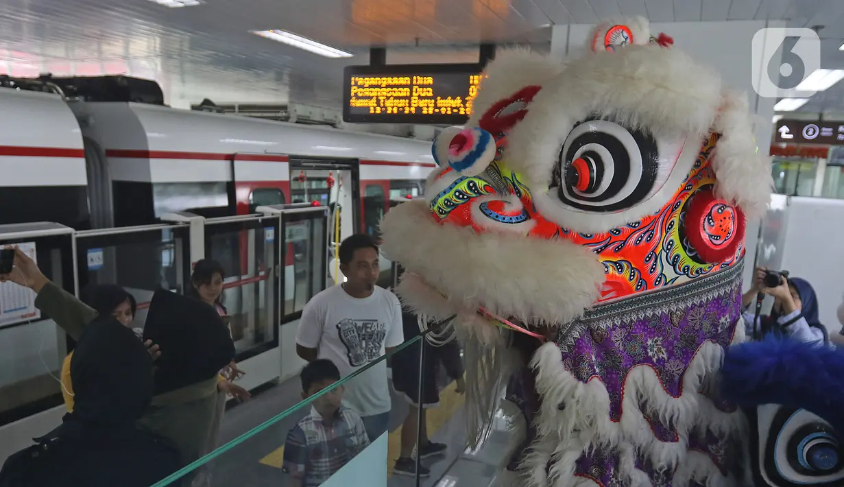 Atraksi Barongsai berkeliling untuk menghibur penumpang di Stasiun LRT Velodrome (25/1/2020). Pertunjukan tersebut dalam rangka perayaan tahun baru Imlek yang ke-2571. (Liputan6.com/Herman Zakharia)