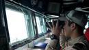 Seorang anggota Angkatan Laut Jepang memantau laut untuk mencari puing-puing AirAsia QZ8501 di Laut Jawa, Rabu (7/1/2015). (AFP Photo/Dewanto Samodro)