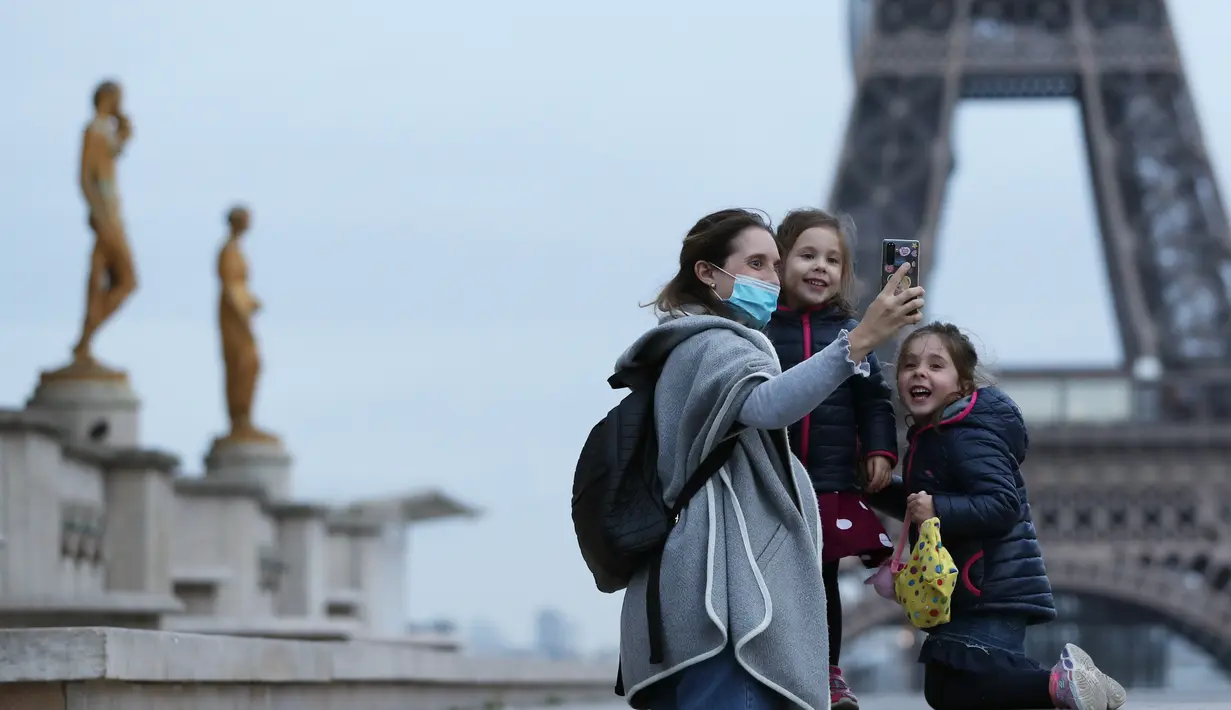 Seorang ibu dan anak-anaknya berswafoto di Lapangan Trocadero dekat Menara Eiffel di Paris, Prancis, pada 16 November 2020. Prancis pada Senin (16/11) melaporkan tambahan 506 kematian akibat virus corona COVID-19, lebih tinggi dibandingkan 302 kematian pada Minggu (15/11). (Xinhua/Gao Jing)
