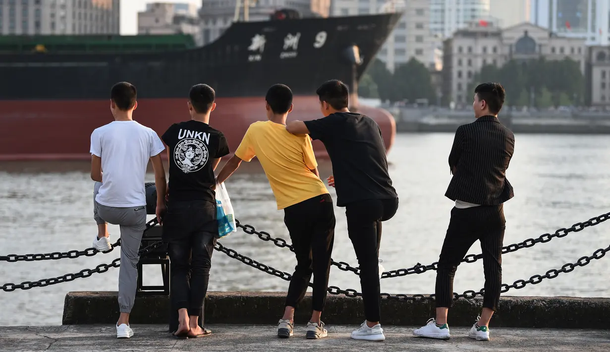 Sejumlah anak muda melihat Sungai Huangpu di distrik keuangan Lujiazui, Shanghai (15/7/2019). Sungai ini mengalir melewati kota Jiaxing. Beberapa jembatan yang melintasi sungai ini adalah Jembatan Songpu, Jembatan Xupu, Jembatan Lupu, Jembatan Nanpu, dan Jembatan Yangpu. (AFP Photo/Hector Retamal)