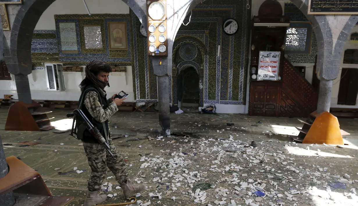 Seorang militan Houthi berjalan diantara reruntuhan sebuah masjid di Yaman, Kamis (24/9/2015). Sebuah ledakan terjadi di Masjid Balili di Sanaa, Yaman. Dikabarkan, 29 orang tewas dan puluhan terluka. (REUTERS/Khaled Abdullah)
