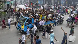 Massa yang tampak gembira mengibarkan bendera di jalan-jalan Dhaka, sebelum ratusan orang menerobos gerbang kediaman resmi Syekh Hasina. (AP Photo/Fatima Tuj Johora)