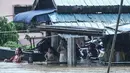 Warga dan anak-anak berada di depan rumah yang terendam banjir di Rantau Panjang, timur laut Malaysia, Selasa (3/1). Akibat hujan lebat yang turun terus menerus selama empat hari di Malaysia, 5.000 warga terpaksa dievakuasi. (AFP PHOTO/STR/Malaysia OUT)