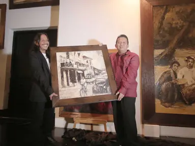 Ketua KEIN, Soetrisno Bachir (kanan) dan pelukis Soehib Toyaroja memegang sebuah lukisan saat acara pembukaan pameran tunggal bertajuk The Spiritual Journey di Kunstkring Art Galeri, Jakarta, Selasa (15/3). (Liputan6.com/Angga Yuniar)