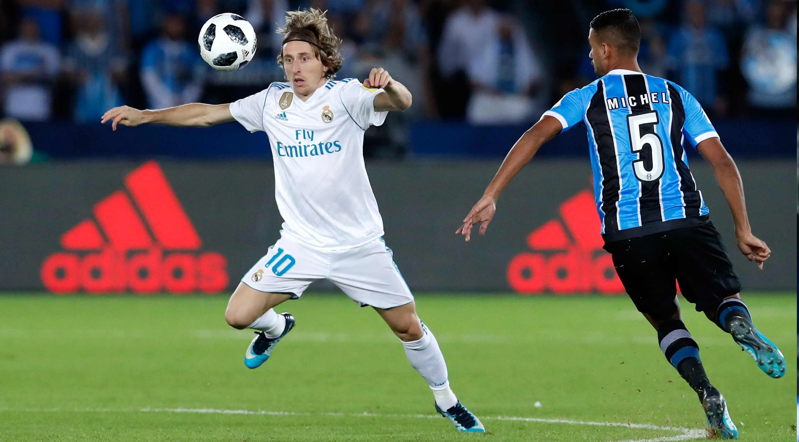 Gelandang Real Madrid, Luca Modric berusaha mengontrol bola dari kawalan pemain Gremio, Michel saat bertanding di pertandingan final Piala Dunia Antarklub 2017 di stadion Zayed Sports City di Abu Dhabi, Uni Emirat Arab, (16/12). (AP Photo / Hassan Ammar)