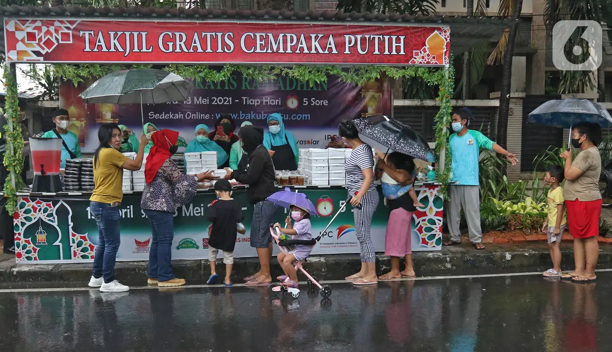 Warga mengantre untuk mendapatkan takjil gratis di Jalan Cempaka Putih Tengah XXI, Jakarta, Rabu (14/4/2021). Berbagai menu takjil dibagikan secara gratis seperti aneka kue, kolak, gorengan, nasi kotak dan lain-lain. (Liputan6.com/Herman Zakharia)