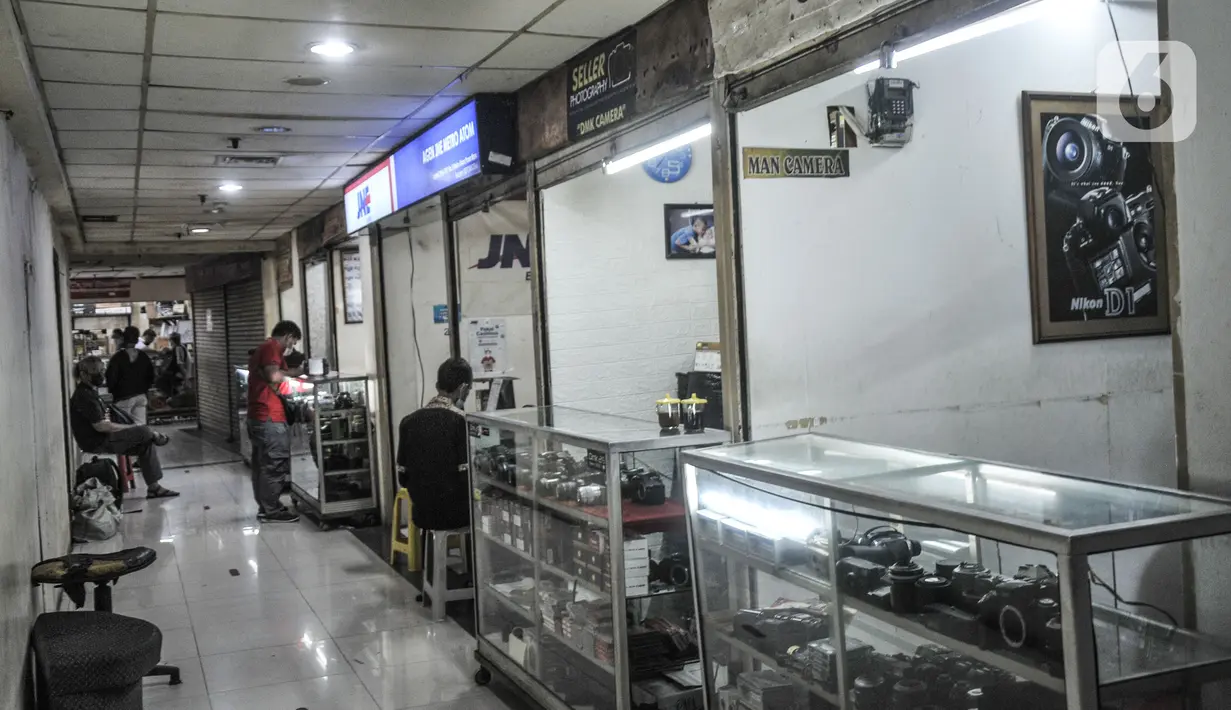 Pedagang menunggu pelanggan di salah satu toko Metro Atom Plaza, Pasar Baru, Jakarta, Senin (15/11/2021). Menurunnya omzet toko dan jasa servis kamera salah satunya dipicu oleh penutupan sementara toko saat PPKM serta sepinya permintaan jasa fotografi.  (merdeka.com/Iqbal S Nugroho)