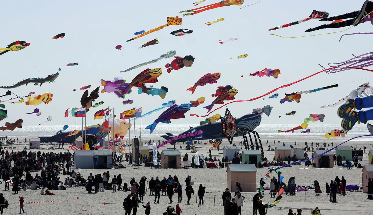 Pengunjung menyaksikan layang-layang terbang selama Festival Layang-layang Internasional ke-31 di Berck, Prancis, (6/4). Festival ini diselenggarakan di Berck-sur-Mer setiap bulan April dan berlangsung selama 10 hari. (AP Photo / Thibault Camus)