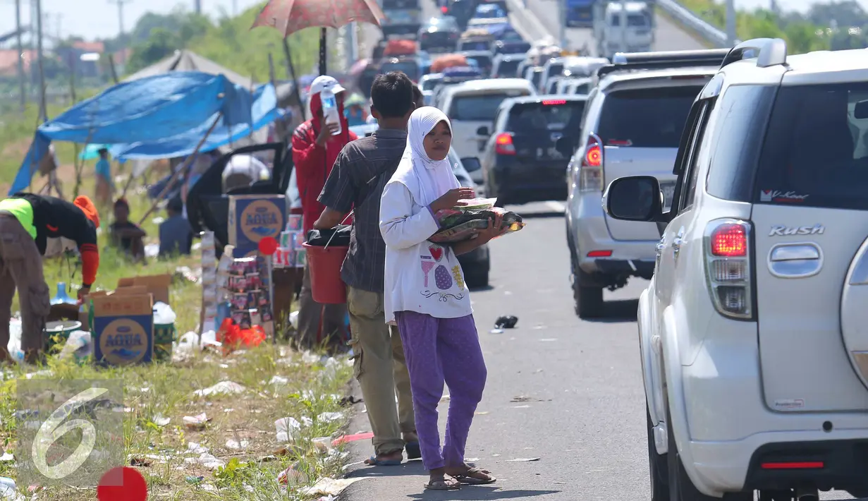Sejumlah anak berjualan di pintu tol keluar Brebes Timur, Jawa Tengah, (3/7).Hari mudik dan libur sekolah, Sejumlah anak di kawasan tersebut berjalan untuk menjajakan barang dagangannya kepada pemudik yang terkena macet. (Liputan6.com/Angga Yuniar)