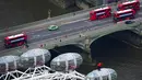 Legenda Inggris Geoff Hurst mengenakan jersey Inggris di final Piala Dunia 1966 berdiri di atas pod komedi putar London Eye memandang ke arah Stadion Wembley di London (9/7/2021). Aksi Geoff Hurst ini demi mendukung timnas Inggris melawan Italia jelang final Euro 2020. (Dominic Lipinski/PA via AP)