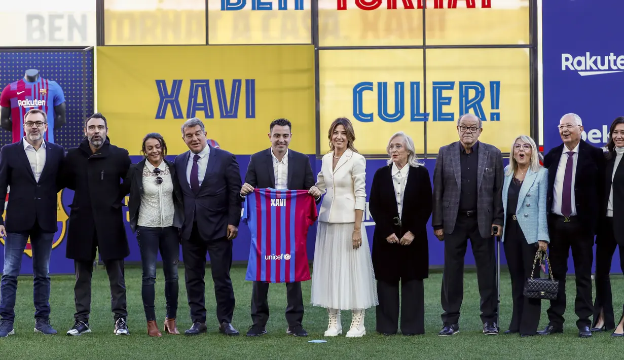 Pelatih baru FC Barcelona Xavi Hernandez (tengah) berpose di samping presiden FC Barcelona Joan Laporta dan anggota keluarganya selama presentasi resminya di stadion Camp Nou di Barcelona, Spanyol, Senin (8/11/2021). (AP Photo/Joan Monfort)