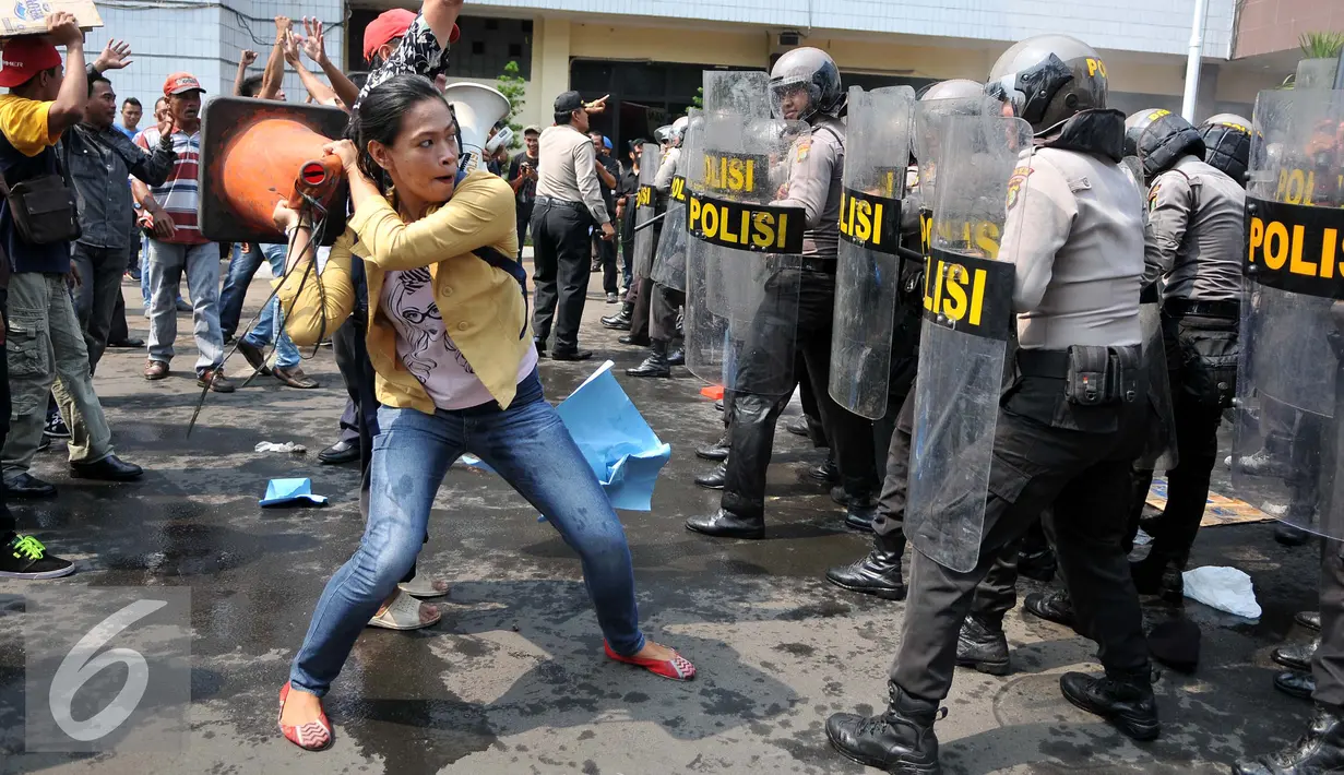 Seorang wanita terlihat menyerang petugas saat simulasi pengamanan pilkada Tangerang Selatan yang digelar Polres Jakarta Selatan, Rabu (9/9/2015). (Liputan6.com/Gempur M Surya)