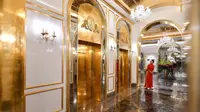 Seorang pegawai berdiri di dekat lift hotel Dolce Hanoi Golden Lake yang baru saja diresmikan di Hanoi, Vietnam pada Kamis (2/7/2020). Hotel tersebut merupakan hotel berlapiskan emas 24 karat pertama di dunia. (Manan VATSYAYANA / AFP)