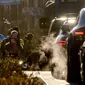Mobil mengeluarkan asap knalpot saat anak-anak berangkat sekolah di Frankfurt, Jerman, 27 Februari 2023. Negara-negara anggota Uni Eropa telah melunakkan proposal badan eksekutif blok tersebut yang bertujuan untuk menurunkan emisi kendaraan. (AP/Michael Probst)