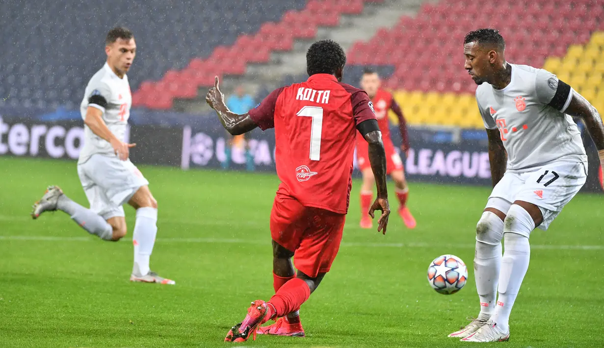 Bek Bayern Munchen, Jerome Boateng, berebut bola dengan penyerang Salzburg, Sekou Koita, pada laga lanjutan Liga Champions 2020/2021 di Stadioin Wals-Siezenheim, Rabu (4/11/2020) dini hari WIB. Bayern Munchen menang 6-2 atas Salzburg. (AFP/Barbara Gindl/APA)