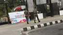 Petugas Satpol PP melintas di salah satu pintu masuk kawasan Gelora Bung Karno, Jakarta, Jumat (20/7). Untuk memperlancar proses persiapan Asian Games 2018, kawasan GBK kembali ditutup untuk umum. (Liputan6.com/Helmi Fithriansyah)