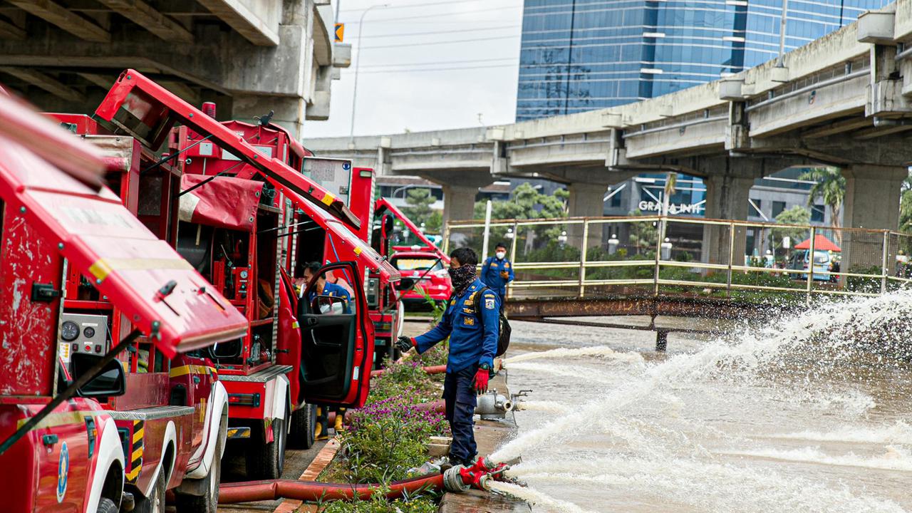 FOTO: Aksi Pemadam Kebakaran Sedot Air Banjir di Cipinang Melayu