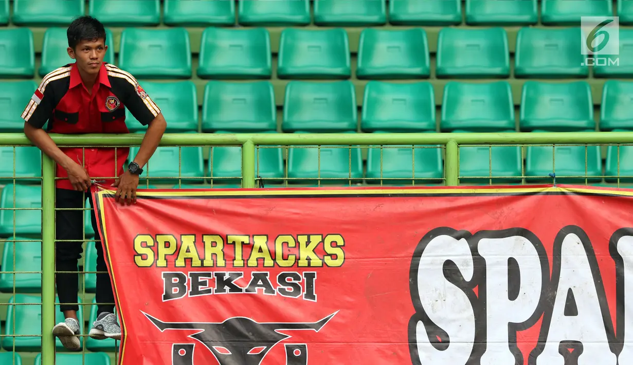Suporter Semen Padang mencabut spanduk usai menyaksikan laga timnya melawan Bhayangkara FC di lanjutan Liga 1 Indonesia di Stadion Patriot Candrabhaga, Bekasi, Sabtu (20/5). Semen Padang kalah 0-1. (Liputan6.com/Helmi Fithriansyah)