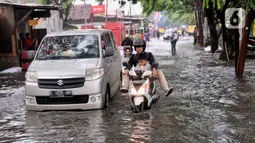 Kendaraan menerobos banjir yang menggenangi Jalan KH. Ahmad Dahlan Cipondoh, Tangerang, Selasa (16/2/2021). Hujan deras yang melanda wilayah Tangerang mengakibatkan ruas jalan alternatif penghubung Tangerang dengan Jakarta tersebut banjir setinggi lutut orang dewasa. (Liputan6.com/Angga Yuniar)