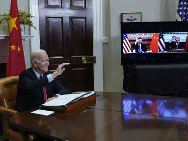 Presiden Joe Biden melambai saat bertemu secara virtual dengan Presiden China Xi Jinping dari Ruang Roosevelt Gedung Putih di Washington, Senin (15/22/2021). Pertemuan dimaksudkan untuk menurunkan ketegangan antara AS dan China selaku dua negara adidaya dunia saat ini. (AP Photo/Susan Walsh)