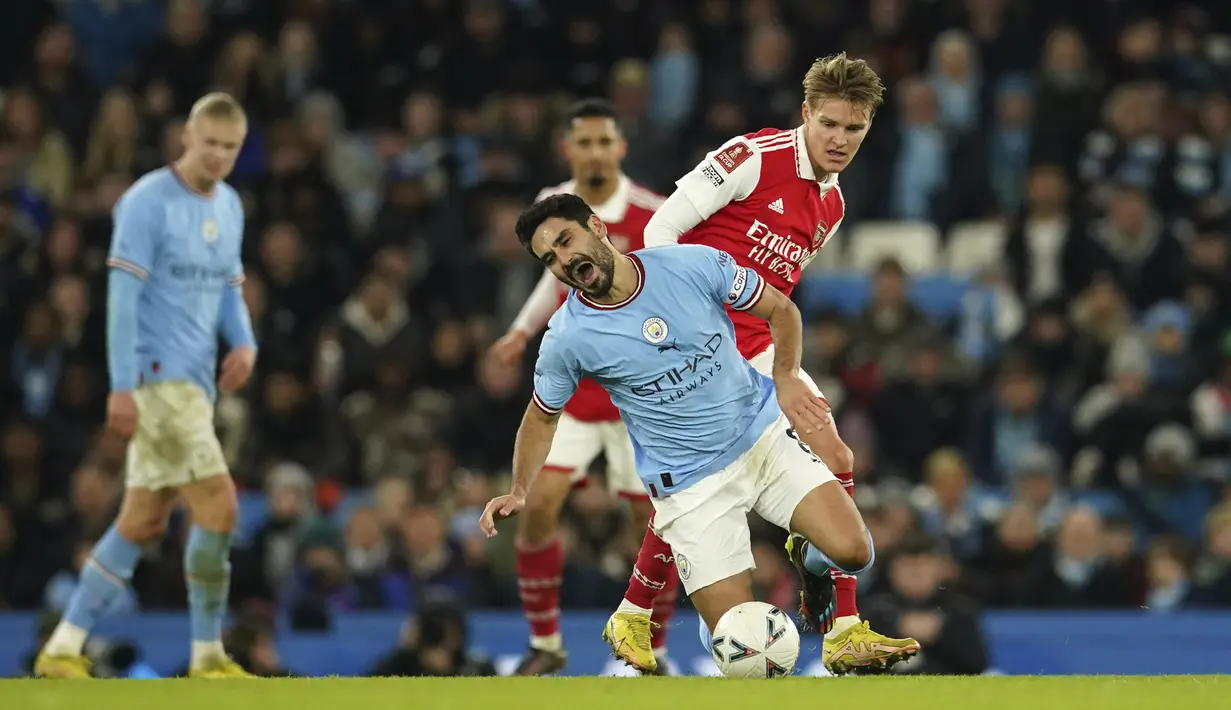 <p>Gelandang Manchester City, Ilkay Gundogan saat dilanggar gelandang Arsenal, Martin Odegaard selama pertandingan putaran ke-4 Piala FA di Stadion Etihad di Manchester, Inggris, Sabtu (28/1/2023). Man City menang tipis atas Arsenal dengan skor 1-0. (AP Photo/Dave Thompson)</p>
