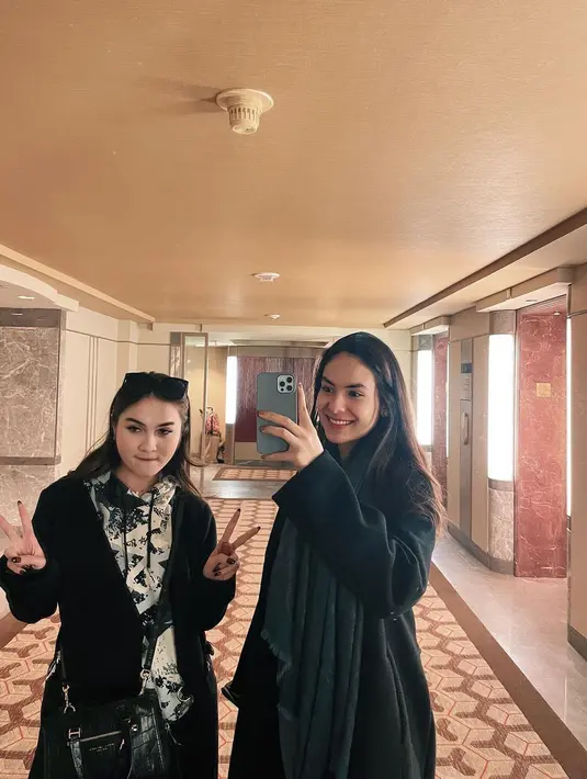 Kompak kenakan long coat warna hitam, Steffi Zamora memadukannya dengan syal polos warna abu-abu, sedangkan Elina Joerg dengan syal bermotif floral. [@steffizaamora]