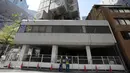 Penjaga keamanan berdiri di lokasi pembongkaran Menara Kapsul Nakagin, bangunan ikonik yang dirancang arsitek Jepang Kisho Kurokawa pada tahun 1972, di distrik Ginza Tokyo, Selasa (12/4/2022). Pekerjaan pembongkaran menara 140 unit kapsul tersebut dimulai Selasa. (AP Photo/Eugene Hoshiko)
