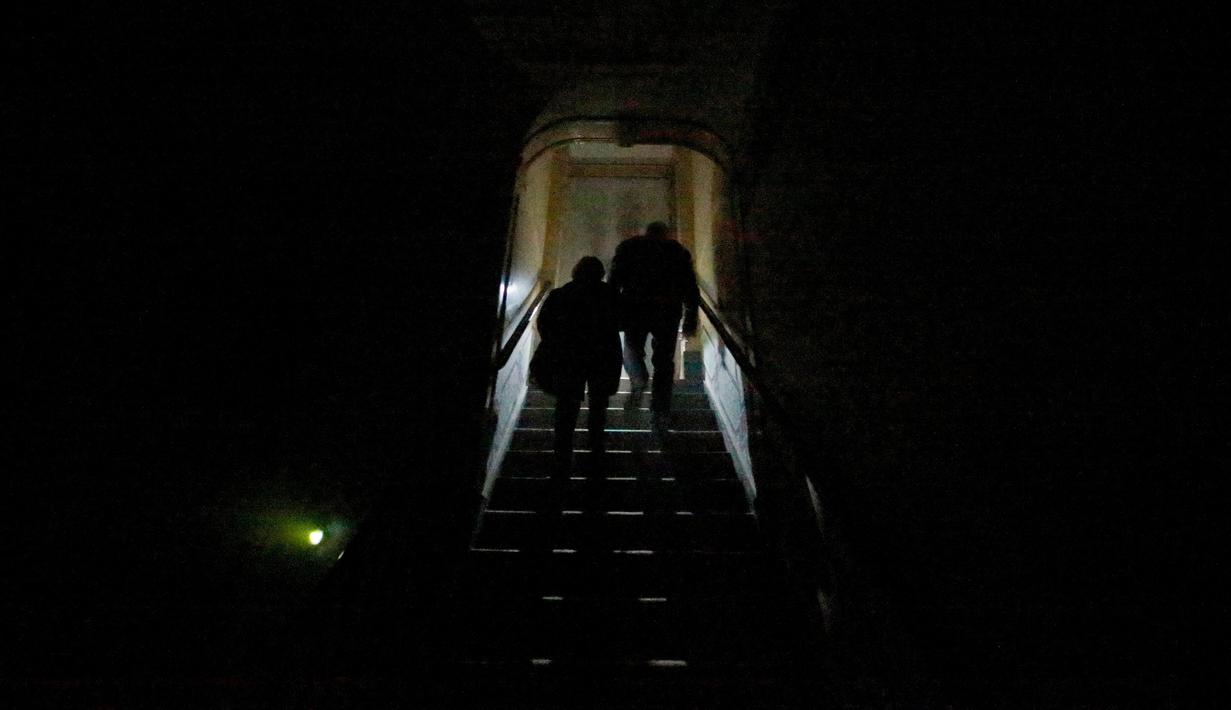 Pengunjung menaiki tangga saat mengunjungi rumah hantu Quinta Nova da Assuncao di Basel, Portugal (13/5). Rumah hantu ini menampilkan penampakan hantu serta jeritan misteri yang dapat menggetarkan nyali pengunjung. (REUTERS/Rafael Marchante)