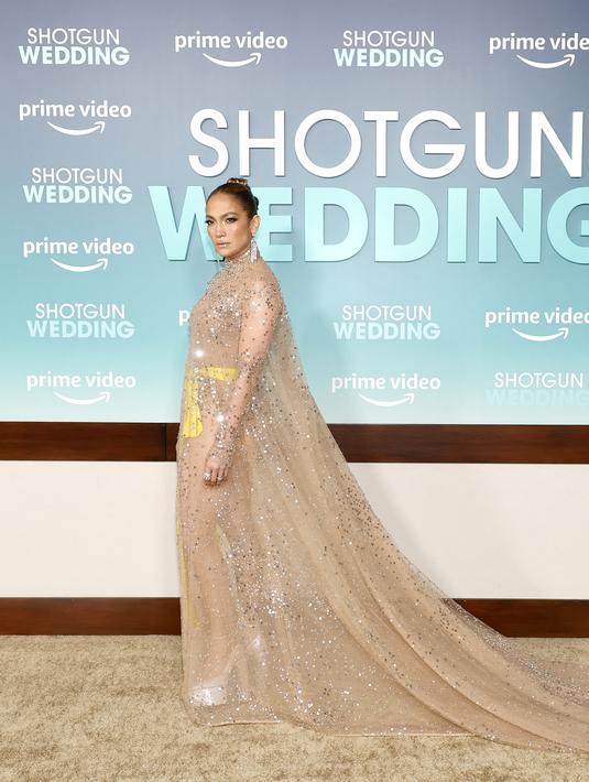 Jennifer Lopez berpose di pemutaran perdana film "Shotgun Wedding" di Los Angeles di TCL Chinese Theater di Hollywood, California (18/1/2023). Rambut coklat keemasannya disapu menjadi sanggul yang apik dan anggun, sementara kulitnya terpancar dengan riasan sempurna. (Emma McIntyre/Getty Images/AFP)