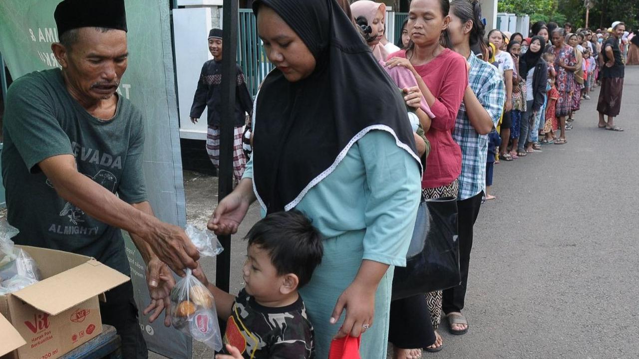 Warga menerima takjil gratis yang dibagikan Dewan Kemakmuran Masjid (DKM)&nbsp;Masjid At-Taqwa, Pondok Kelapa, Jakarta, Jumat (22/3/2024). Setiap hari menjelang waktu berbuka puasa, pengurus Masjid At-Taqwa membagikan ratusan paket takjil gratis berupa be