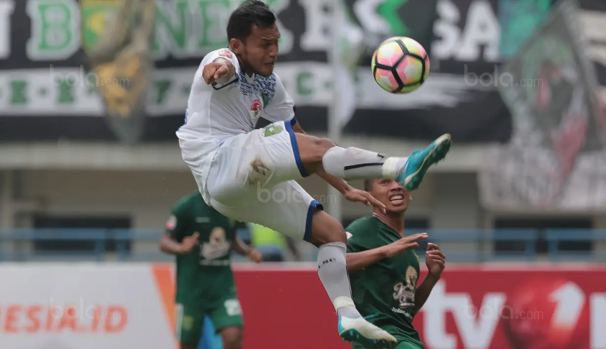 Aksi pemain PSPS Riau, Dendi Sembiring menghalau bola dari kejaran pemain Persebaya, Irfan Jaya pada laga 8 Besar Liga 2 Grup Y di Stadion GBLA, Bandung, Sabtu (18/11/2017). Persebaya Menang 1-0. (Bola.com/Nicklas Hanoatubun)