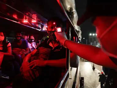 Polisi memeriksa suhu tubuh penumpang dalam jeepney di pos pemeriksaan virus corona COVID-19 di Manila, Filipina, Senin (16/3/2020). Polisi beserta petugas lalu lintas dan petugas desa melakukan pengecekan suhu tubuh warga untuk mencegah penyebaran virus corona COVID-19. (AP Photo/Aaron Favila)