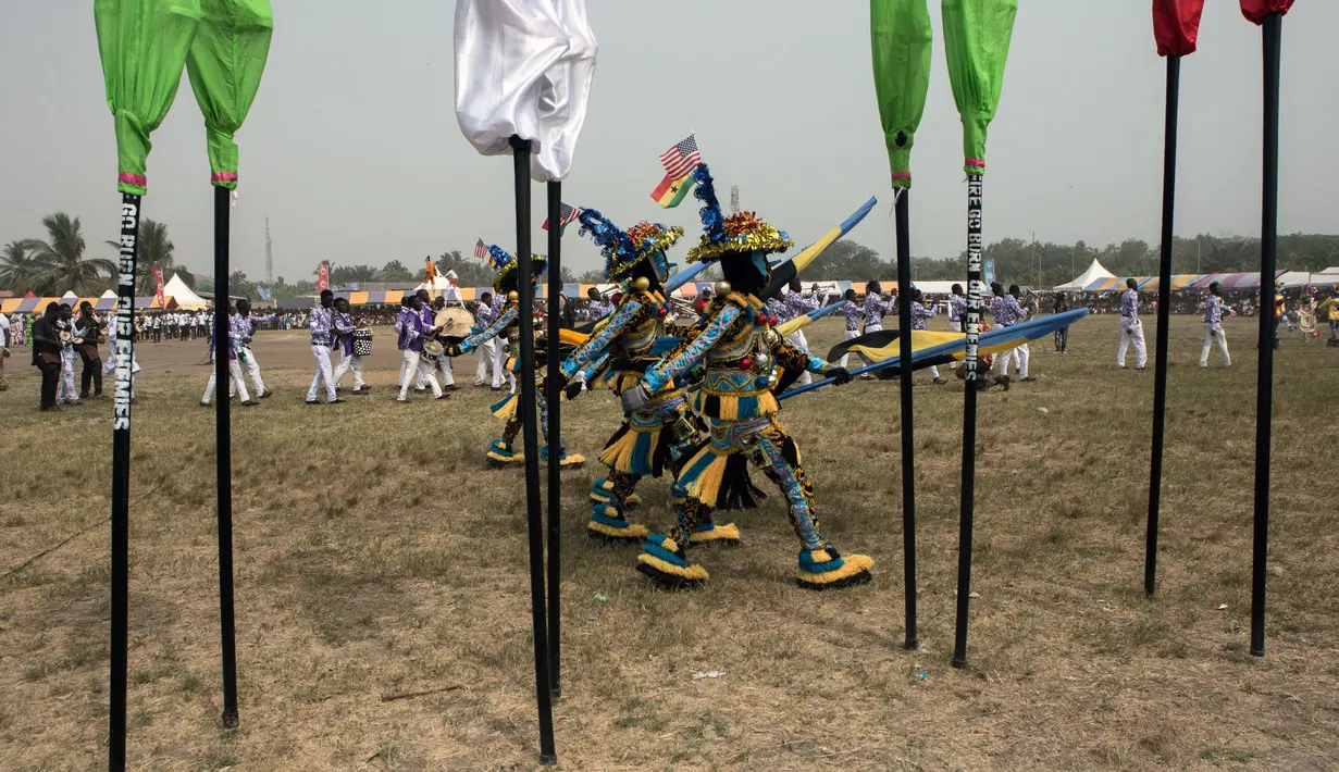 Sejumlah peserta berbaris saat  acara Winneba Fancy Dress, Ghana, Senin (2/1). The Fancy Dress festival adalah festival topeng yang diadakan setiap tahun di bulan Januari oleh orang-orang dari Winneba. (AFP PHOTO / Ruth McDowall)