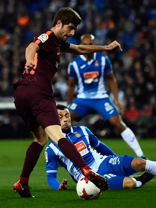 Gelandang Barcelona, Sergi Roberto berebut bola dengan gelandang Espanyol, Javi Fuego pada laga leg pertama perempatfinal Copa del Rey di Stadion RCDE, Kamis (18/1). Barcelona dipermalukan rival sekotanya Espanyol dengan skor 0-1. (Josep LAGO / AFP)