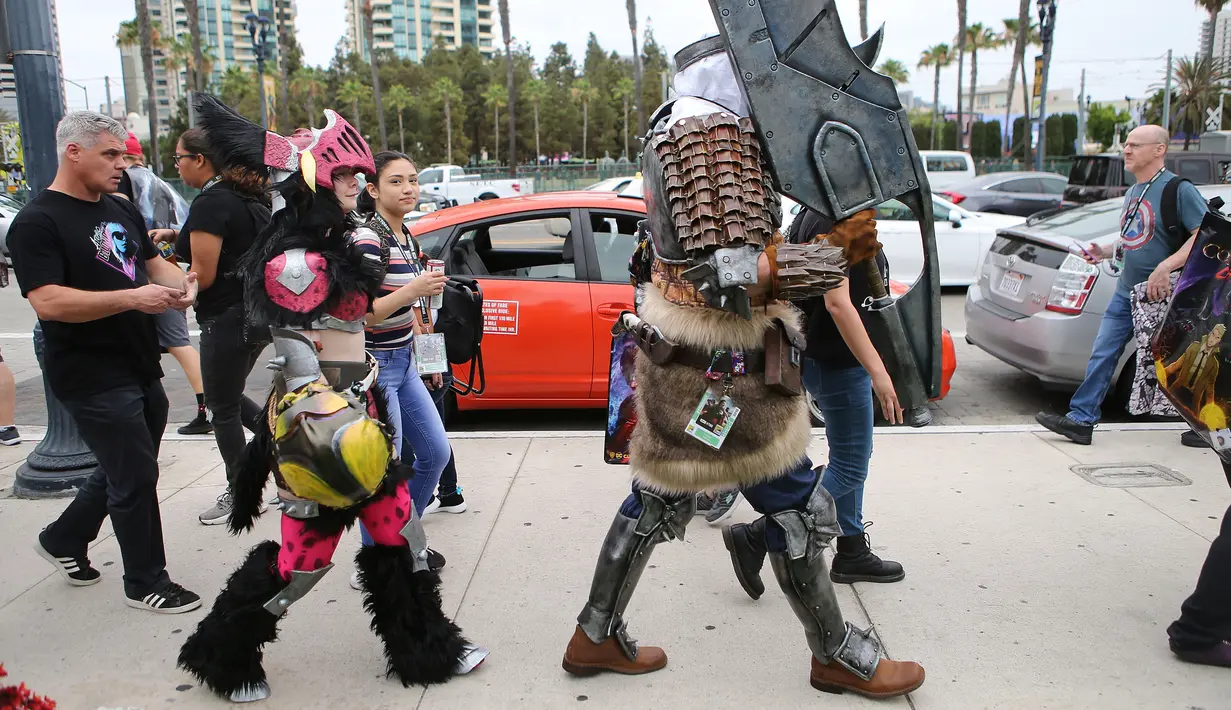 Para cosplay berjalan di luar Comic-Con, San Diego, California, Amerika Serikat, Jumat (20/7). (Mario Tama/Getty Images/AFP)