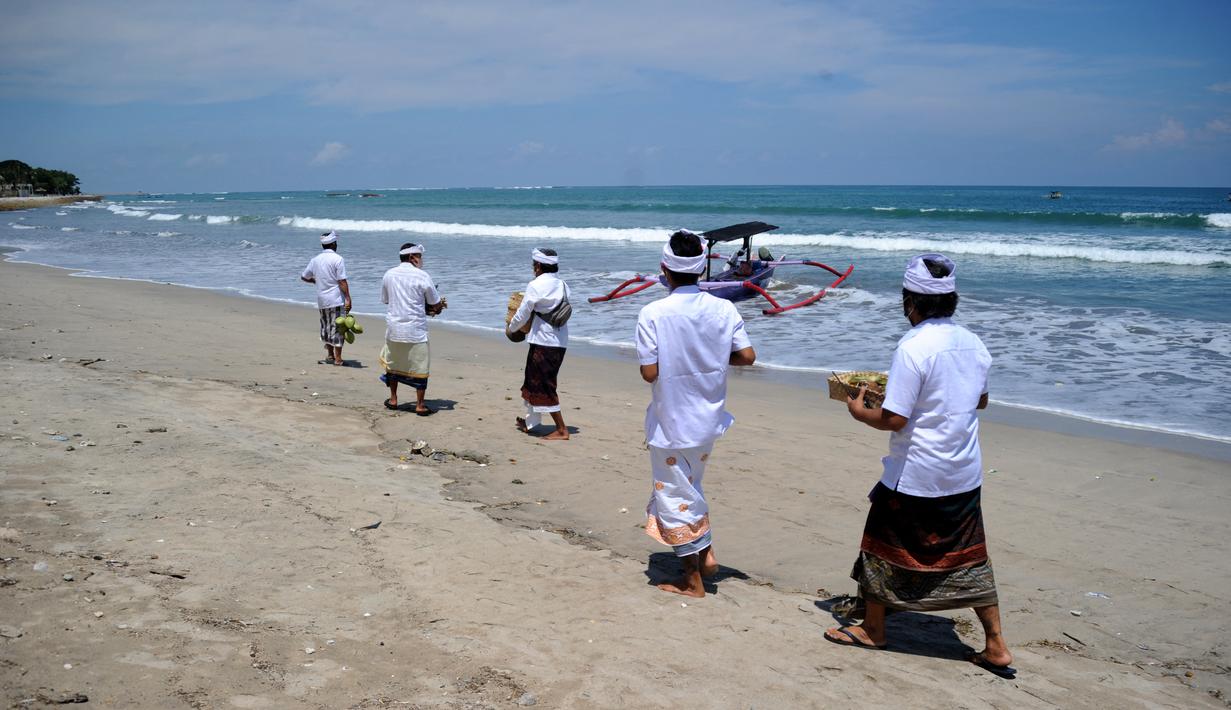 Umat Hindu menghadiri upacara Melasti menjelang Hari Raya Nyepi Tahun Baru Saka 1943 di Pantai Kuta, Bali (11/3/2021). Ritual Melasti untuk menyucikan alam agar Hari Raya Nyepi dapat berjalan  hening serta damai.(AFP/Sonny Tumbelaka)
