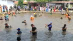 Warga menangkap ikan dengan tangan kosong saat acara Ngubek Empang di kawasan Bojongsari, Depok, Jawa Barat, Senin (15/5/2023). Kegiatan ini merupakan rangkaian Lebaran Depok Jilid 5. (merdeka.com/Arie Basuki)