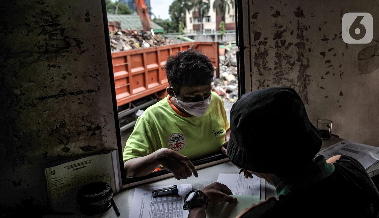 Petugas mendata sampah sungai yang diangkut saat tiba di TPSS Perintis Kemerdekaan, Jakarta, Selasa (16/2/2021). Selama musim hujan, volume sampah yang diangkut dari sungai di Jakarta meningkat hingga 600 meter kubik per hari. (merdeka.com/Iqbal S. Nugroho)